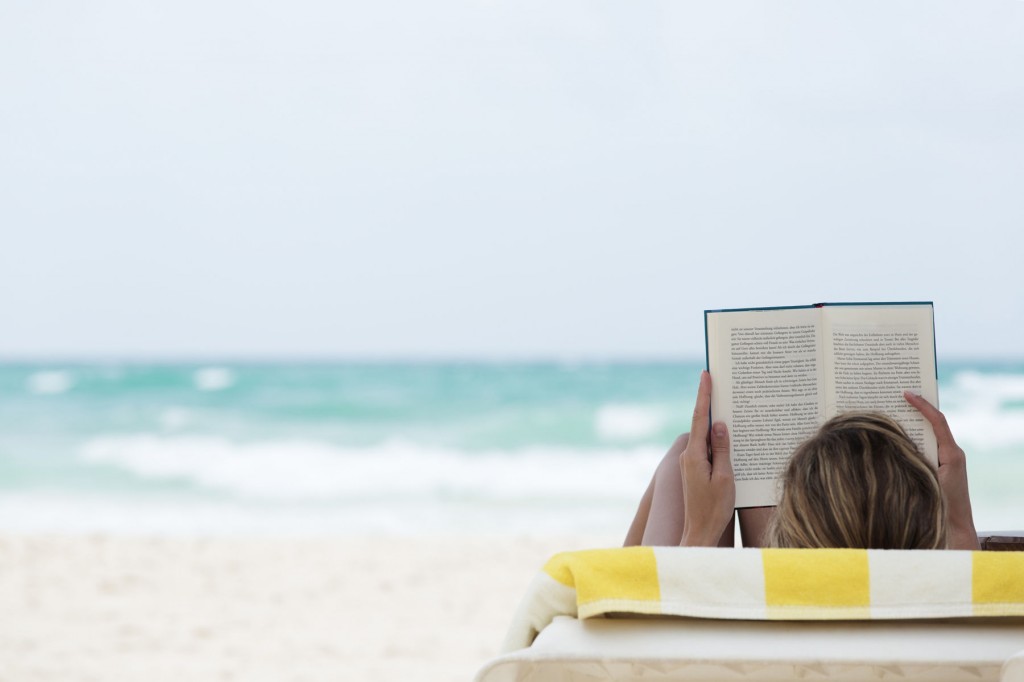 woman reading book at the beach
